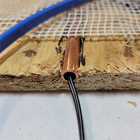 Let the copper tubing hold the radiant floor heat temperature probe.